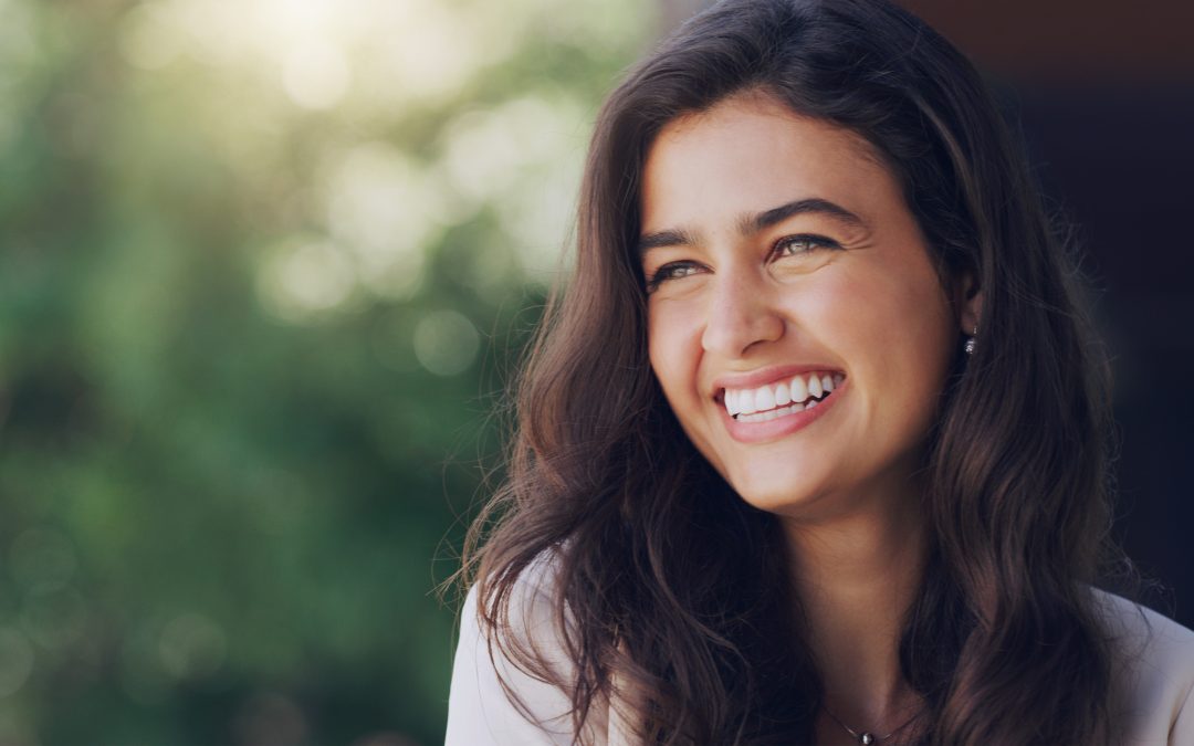 beautiful young woman smiling confidently outdoors